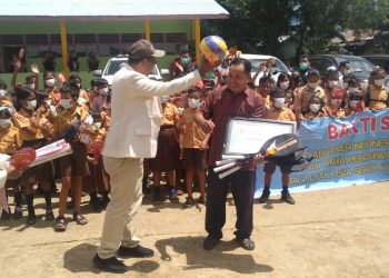 Ketua IAI Pengurus Cabang Sanggau menyerahkan piagam penghargaan dan bantuan alat olahraga kepada Kepala Sekolah SDN 06 Balai Ingin. Foto: Kiram Akbar/Equator Online