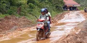 Warga melintasi jalan berlumpur Jalur Pinoh menuju Ella Hilir, di Desa Semadin Lengkong, Kabupaten Melawi. Foto Dedi Irawan/Equator Online