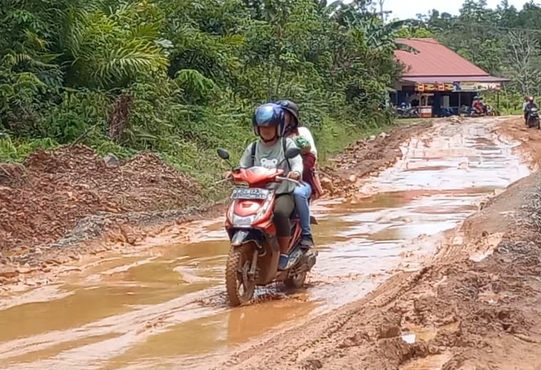 Warga melintasi jalan berlumpur Jalur Pinoh menuju Ella Hilir, di Desa Semadin Lengkong, Kabupaten Melawi. Foto Dedi Irawan/Equator Online