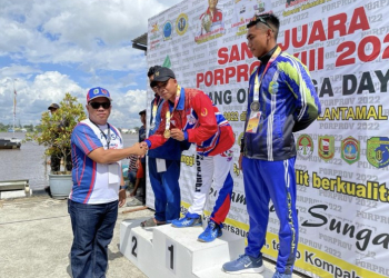 Hairudin Penasehat PODSI Kapuas Hulu menyerahkan medali emas kepada tim Dayung Kapuas Hulu