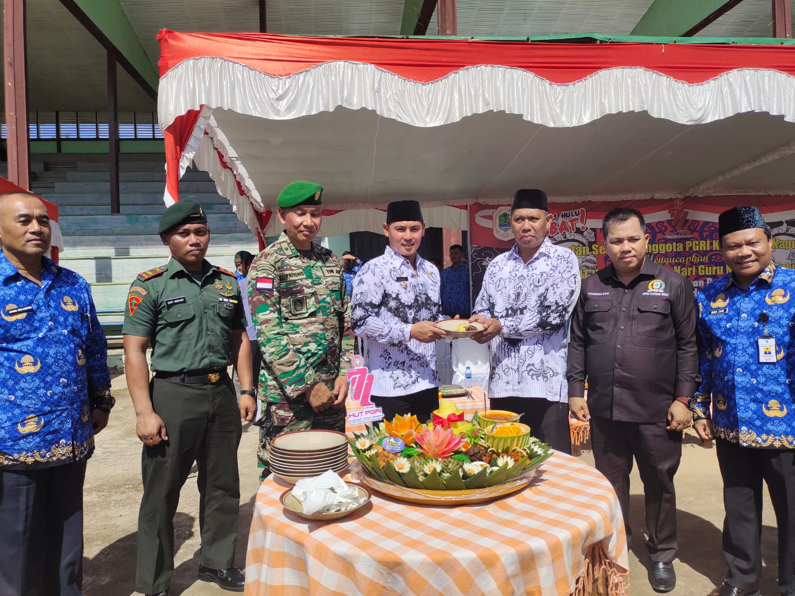 Wakil Bupati Kapuas Hulu memberikan tumpeng di acara HUT Guru ke 77