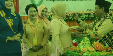 Sekda Kapuas Hulu Mohd Zaini memberikan potongan tumpeng kepada Ketua DWP Kapuas Hulu Nursyamsiah dalam acara puncak peringatan HUT DWP Kapuas Hulu ke 23
