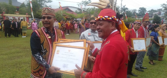 Foto--Bupati Sanggau, Paolus Hadi menyerahkan tiga piagam penghargaan kepada Kepala Dinas Kependudukan dan Catatan Sipil (Disdukcapil) Sanggau, Eduardus Evald usai apel HUT ke-66 Pemprov Kalbar di halaman Kantor Bupati Sanggau--Kiram Akbar