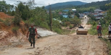 Sertu Budiyono Babinsa Kodim 1206 Putussibau Koramil 11/Silat Hilir saat membantu perbaiki jalan