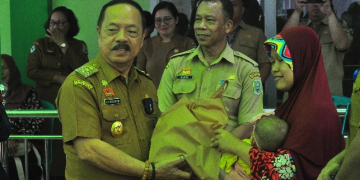 Foto---Wakil Bupati Sanggau, Yohnes Ontot menyerahkan bingkisan kepada peserta Posyandu pada acara pencanangan Posyandu Online di Posyandu Teratai, Gang Amal, Kelurahan Tanjung Kapuas, Selasa (18/04/2023)-- Kiram Akbar