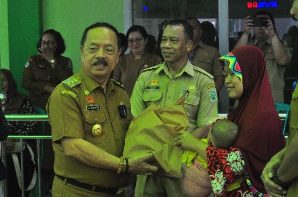 Foto---Wakil Bupati Sanggau, Yohnes Ontot menyerahkan bingkisan kepada peserta Posyandu pada acara pencanangan Posyandu Online di Posyandu Teratai, Gang Amal, Kelurahan Tanjung Kapuas, Selasa (18/04/2023)-- Kiram Akbar