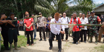 Foto---Wabup Yohanes Ontot melakukan ritual pancung bambu ketika tiba di lokasi pengukuhan---Alfian Diskominfo Sanggau