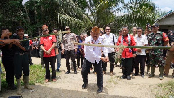 Foto---Wabup Yohanes Ontot melakukan ritual pancung bambu ketika tiba di lokasi pengukuhan---Alfian Diskominfo Sanggau