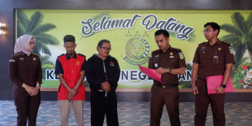 Foto---Kepala Seksi (Kasi) Intelijen Kejaksaan Negeri Sanggau, Adi Rahmanto menyerahkan surat Surat Keputusan Penghentian Penuntutan (SKP2) atas penghentian Penuntutan berdasarkan keadilan restorative justice kepada tersangka disaksikan penuntut umum, korban dan awak media, Senin (09/10/2023)---ist