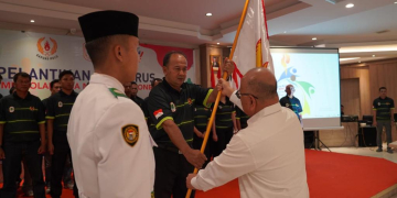 Ketua KONI Kalbar Fahrudin Siregar saat menyerahkan bendera Pataka kepada Ketua KONI Kapuas Hulu Anwar Sanusi