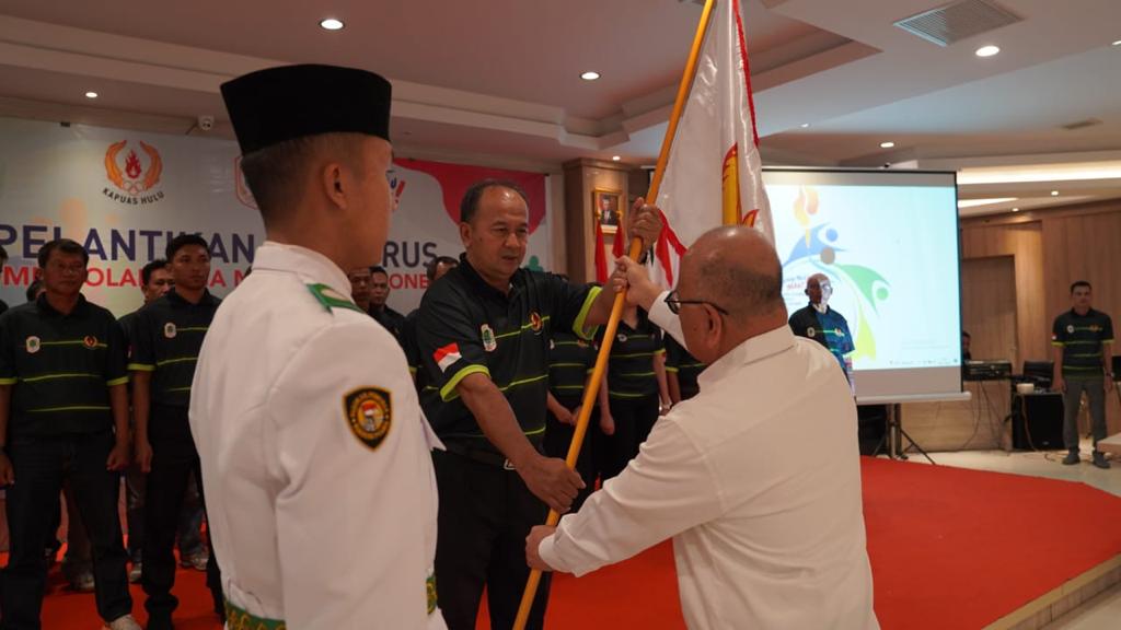 Ketua KONI Kalbar Fahrudin Siregar saat menyerahkan bendera Pataka kepada Ketua KONI Kapuas Hulu Anwar Sanusi